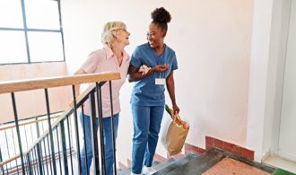A Generations nurse helps an elderly woman up the stairs assisted living generations llc